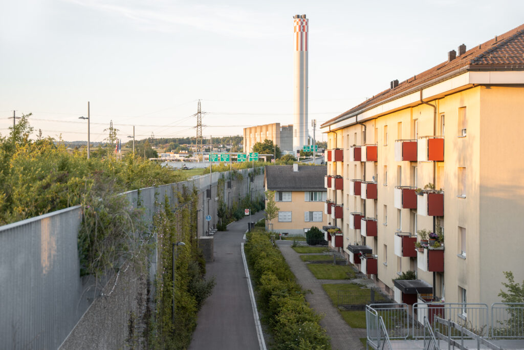 Hausfront gegenüber einer begrünten Infrastrukturanlage beim Ueberlandpark in Schwamendingen. Binding Preis für Biodiversität 2026.